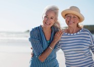 Two older woman outside on windy beach